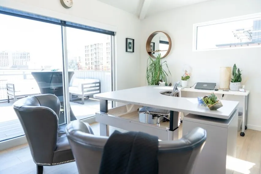 Modern, clean desk with a calculator, a set of house keys, and a pen, symbolizing the financial analysis involved in a hom...