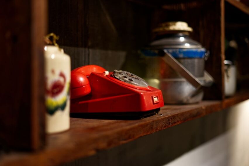 Vintage black rotary phone sits next to a sleek modern smartphone on a clean background, symbolizing the disruption of old...