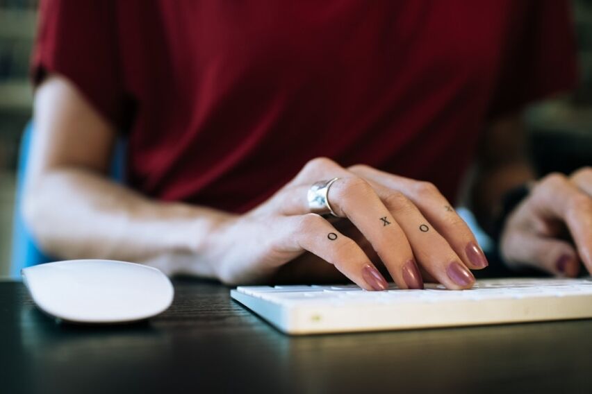 Person sits at a clean, modern desk, using a calculator next to a set of house keys, symbolizing smart financial planning ...
