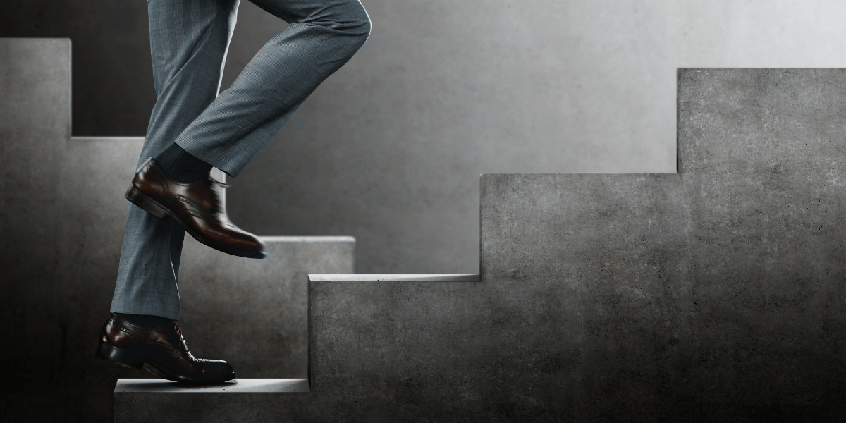 A person climbing steps representing the steps to a career in real estate.