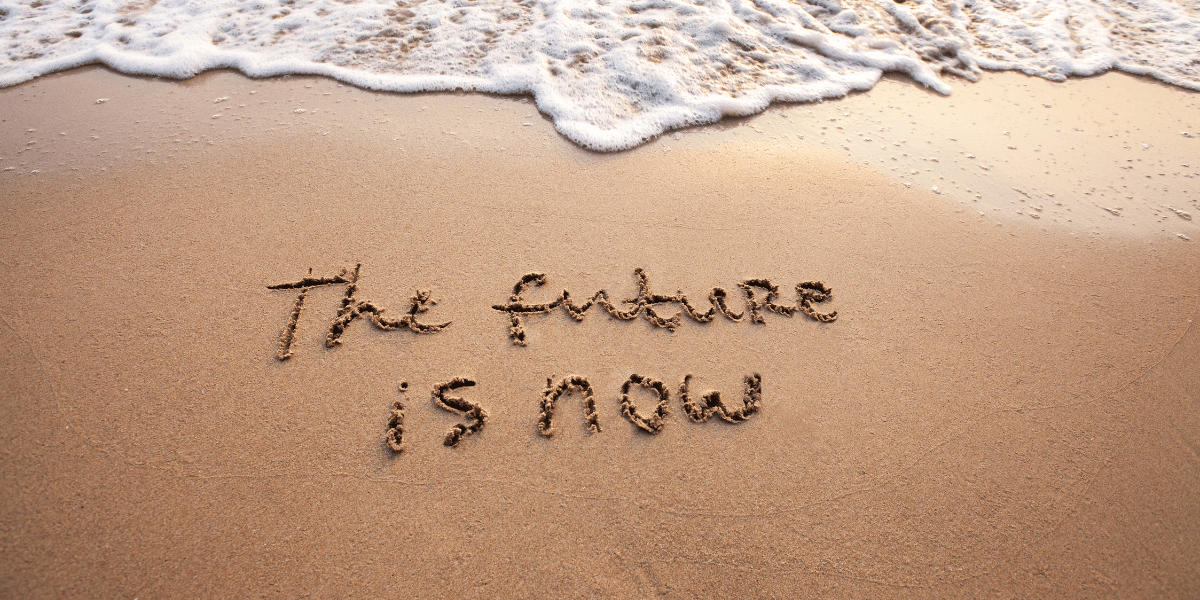 A beach with "The Future is Now" carved into the sand