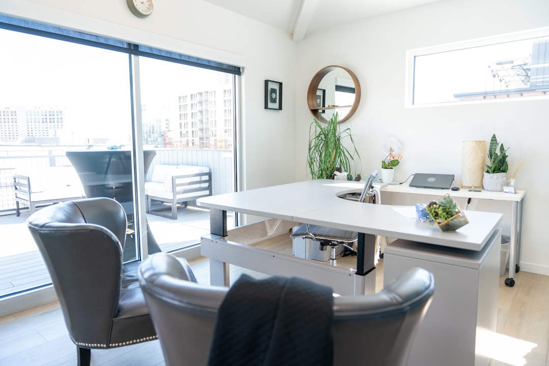 Modern, clean desk with a calculator, a set of house keys, and a pen, symbolizing the financial analysis involved in a hom...