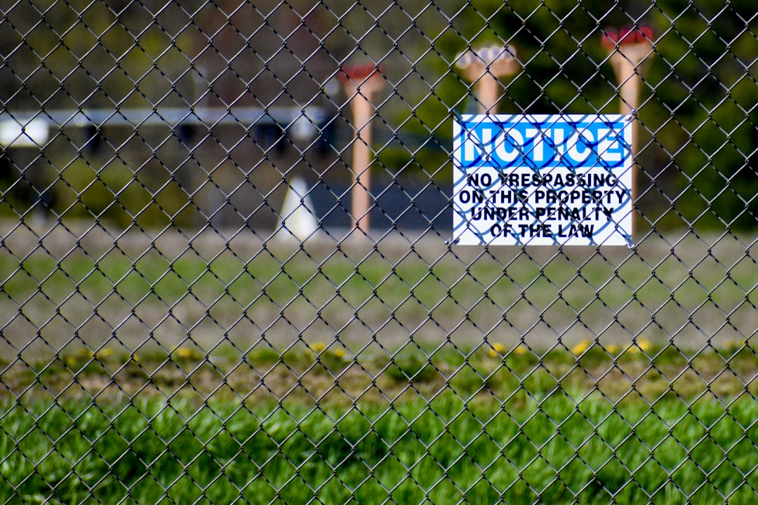 A real estate 'Sold' sign standing on a neat lawn in front of a beautiful, modern suburban home on a sunny day, signifying a successful sale.