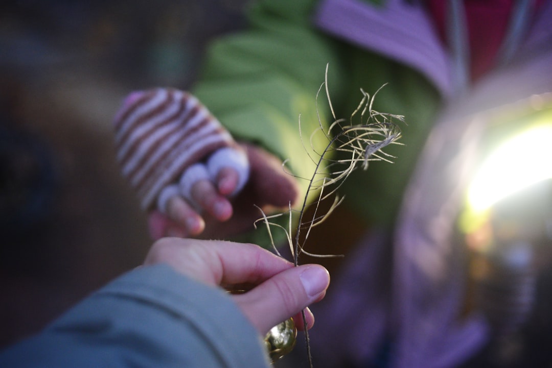 A dramatic photo showing a large hand manipulating a miniature house with strings, illustrating the concept of being controlled by hidden fees in real estate.