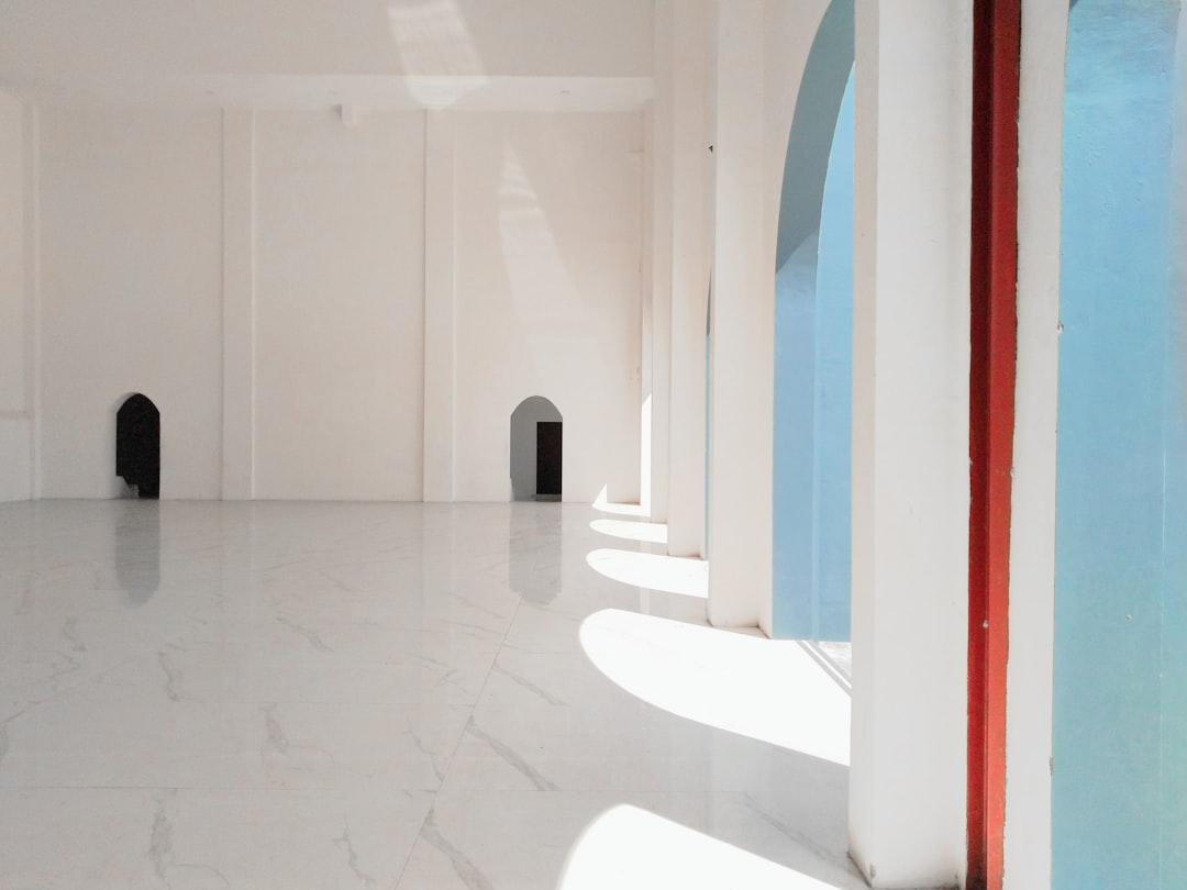A stark, empty room in a modern luxury home with bright light coming through a large window, representing the loss of equity from high commission fees.