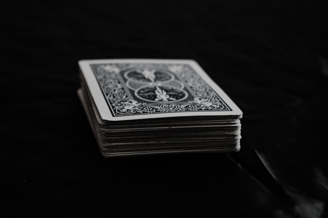 Carefully constructed house of playing cards looking unstable on a bright, clean background, symbolizing the fragile myth ...