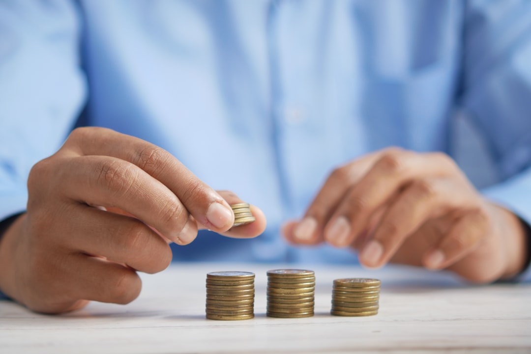 A close-up, professional shot of one hand giving a large stack of cash to another, illustrating the significant commission payment when selling a home.