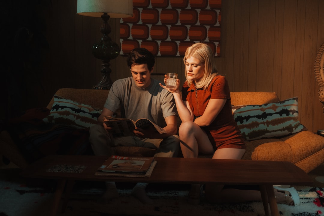 A couple sits together at a table with a worried expression, reviewing a stack of official documents related to their home sale, symbolizing financial stress.
