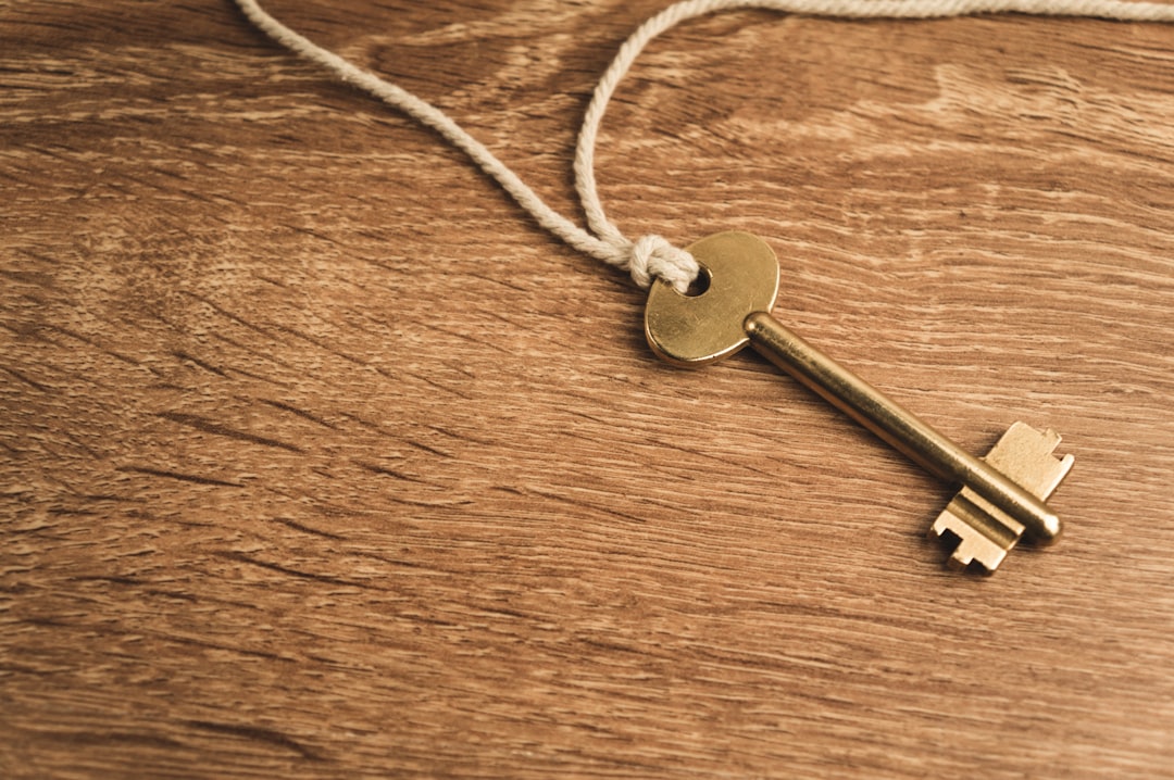 A single house key rests on a simple, signed document on a clean, bright surface, illustrating a straightforward and fair real estate deal.