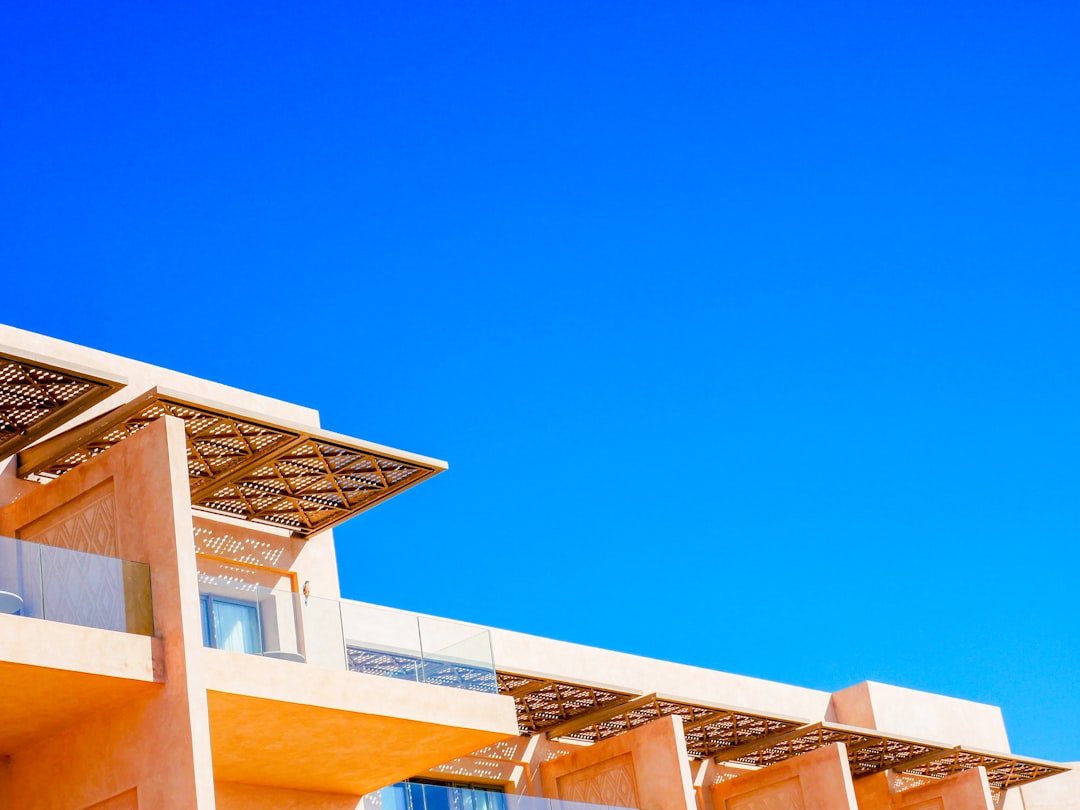 The stunning, minimal exterior of a modern luxury home on a bright, sunny day, representing the significant asset homeowners are paying high commissions on.