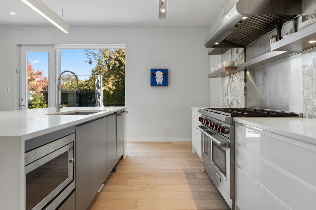 The interior of a bright, modern, and minimalist kitchen with clean lines and high-end finishes, representing the value a homeowner seeks to maximize when selling.