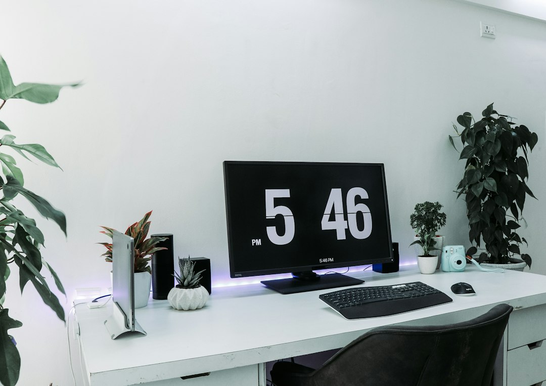 A small toy dinosaur sits on a clean, modern desk next to a computer, representing an extinct or outdated business model in a contemporary professional setting.