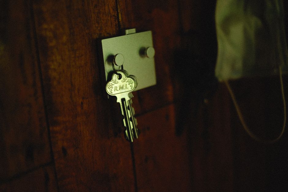 A close-up, professional shot of a modern key turning in the lock of a stylish front door, representing the act of unlocking a home's trapped financial value.