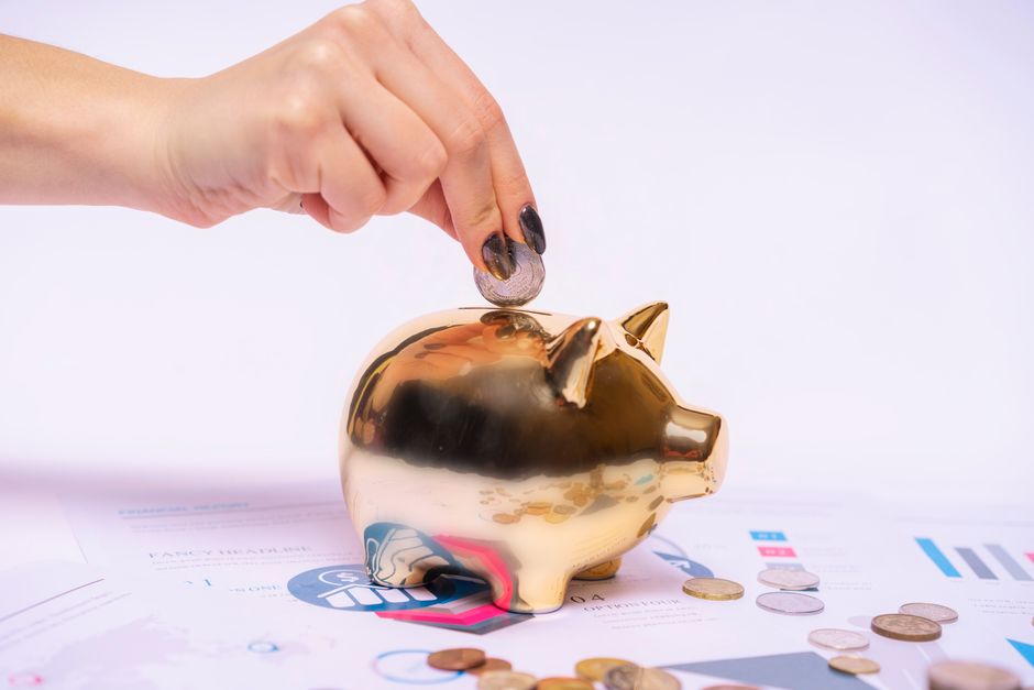 A house-shaped piggy bank with coins being removed from it, visually depicting the loss of home equity due to high commission rates.