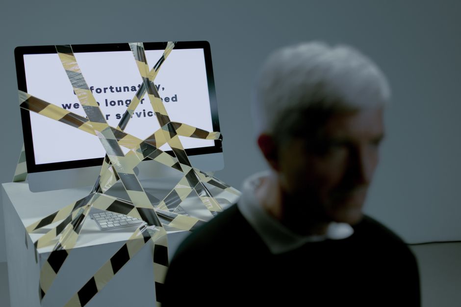 Well-dressed business professional looks frustrated while entangled in a web of red tape, symbolizing being trapped by an ...