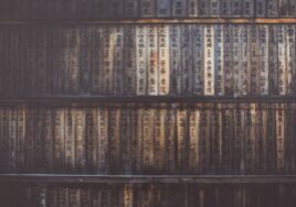 Close-up of a dusty stack of old VHS video cassettes on a shelf, symbolizing an outdated and obsolete business model.