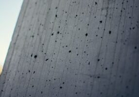 Close-up photograph of a cracked and crumbling concrete foundation of a house, symbolizing the slow erosion of home equity.
