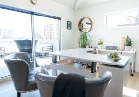 Modern, clean desk with a calculator, a set of house keys, and a pen, symbolizing the financial analysis involved in a hom...