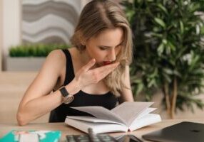 Person sits at a modern desk, looking shocked and stressed while reviewing a financial document, representing the high cos...
