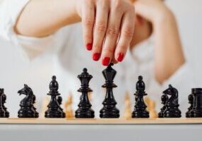 Single, minimalist chess piece making a strategic move on a brightly lit chessboard, symbolizing negotiation and advantage...