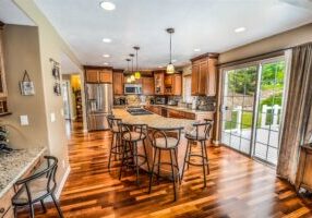 Smiling, professional real estate agent hands the keys to a new home to a happy couple, representing a successful full-ser...