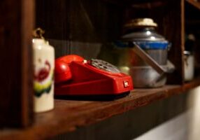 Vintage black rotary phone sits next to a sleek modern smartphone on a clean background, symbolizing the disruption of old...